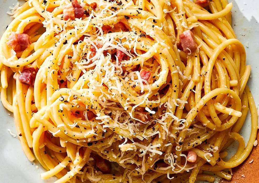 Gli spaghetti adagiati su un piatto con un po' di pecorina sopra