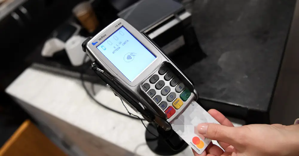 Un dispositivo POS con la carta di credito infilata per completare la transazione