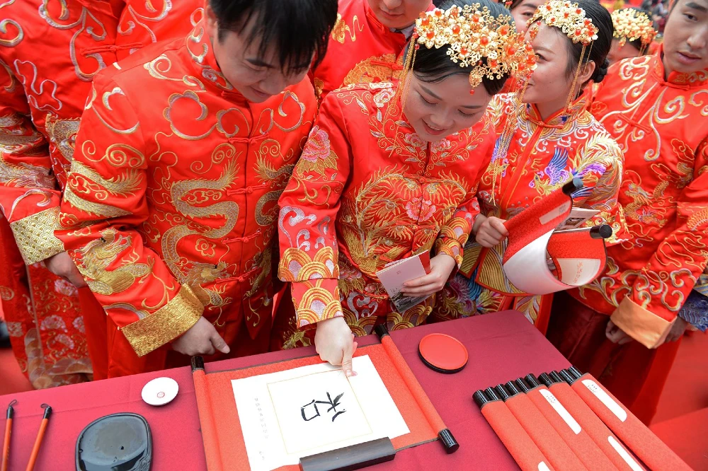 Una coppia di sposi cinesi mette le proprie impronte digitali sul documento ufficiale