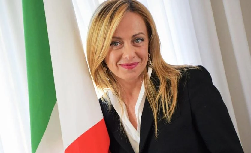 La premier accanto alla bandiera italiana