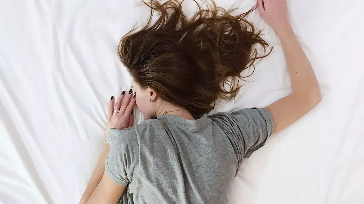 Una donna sdraiata sul letto a pancia in giù