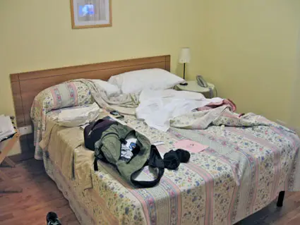 Il lettone disfatto della mia camera d'albergo