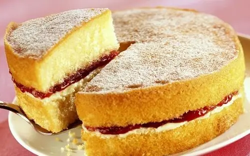 Pan di spagna farcito al cioccolato Una torta con una fetta che viene asportata con un cucchiaio