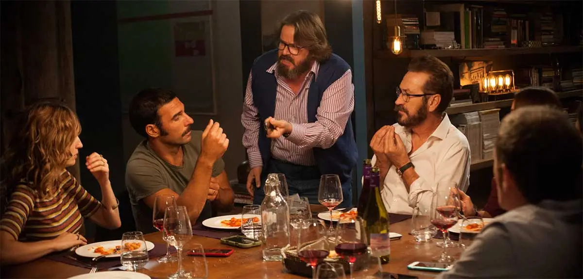 Una scena del film con i protagonisti a discutere animatamente seduti intorno al tavolo