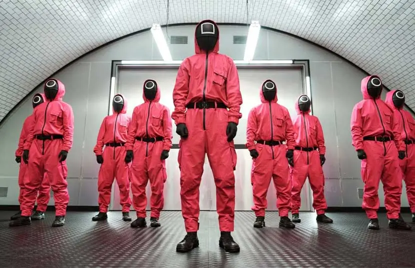 Un gruppo di soldati con uniforme rossa e cappuccio, ed il volto coperto da una maschera con un simbolo che indica il grado