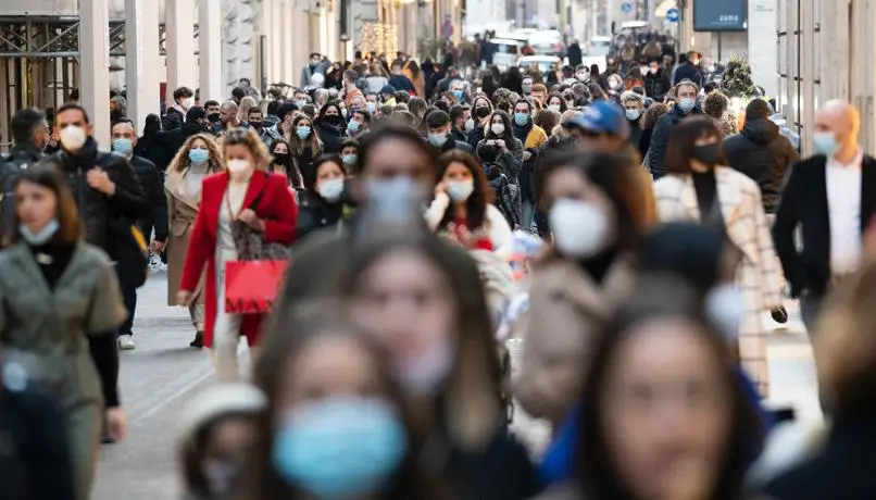 Un viale del centro città affollato di gente che passeggia in un pomeriggio d'inverno