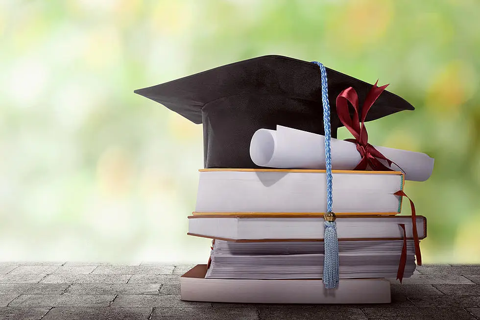 il tipico cappello da laureato, anche noto come tocco, appoggiato su una pila di libri