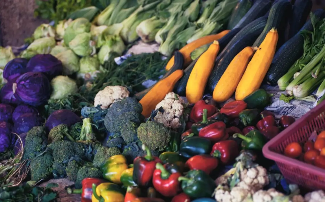 Verdure di stagione esposte all'ingresso di un fruttivendolo