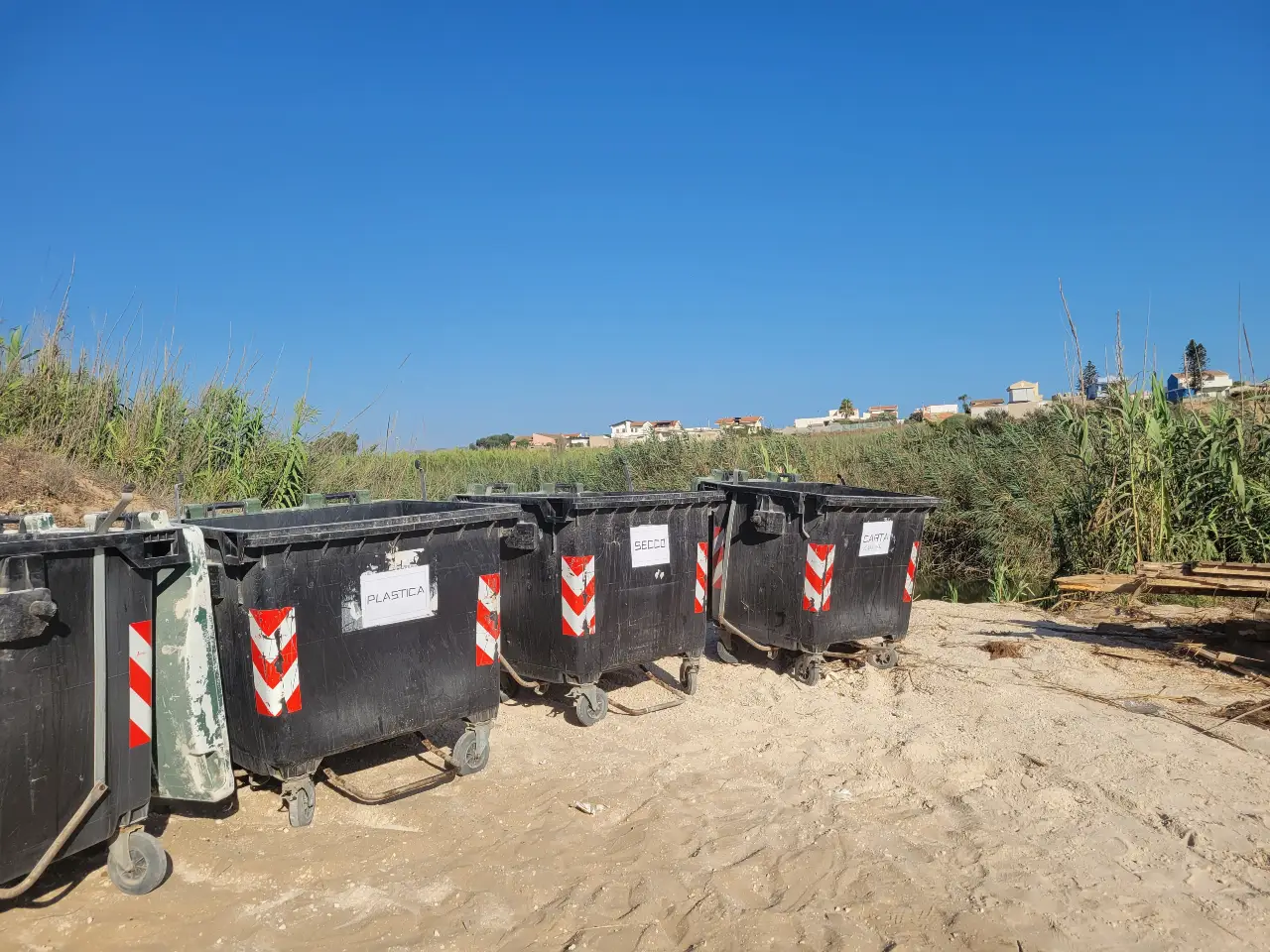 Alcuni bidoni della spazzatura vicino alla spiaggia