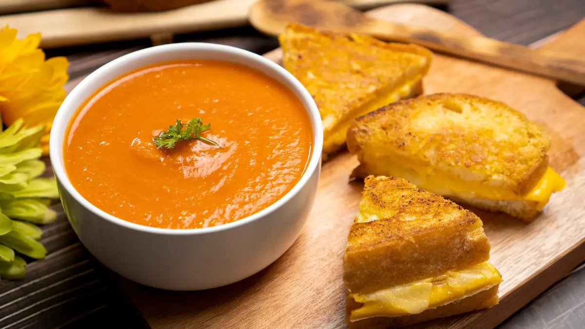 Una scodella di vellutata di pomodoro ed un tramezzino al formaggio