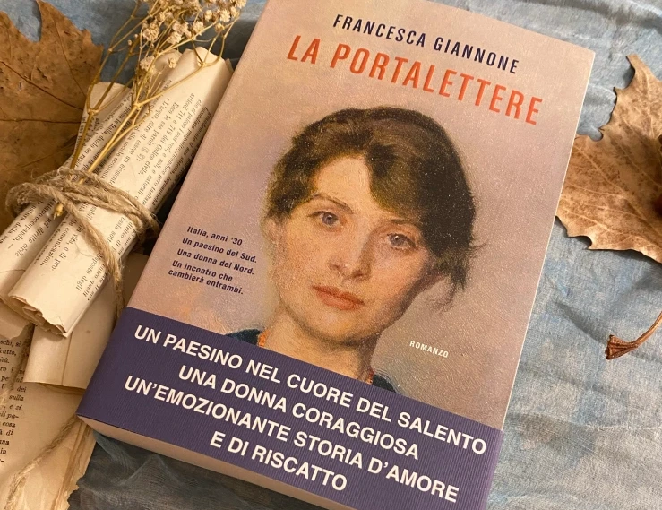 Il libro poggiato su un tavolo accanto a dei rotoli di carta decorati