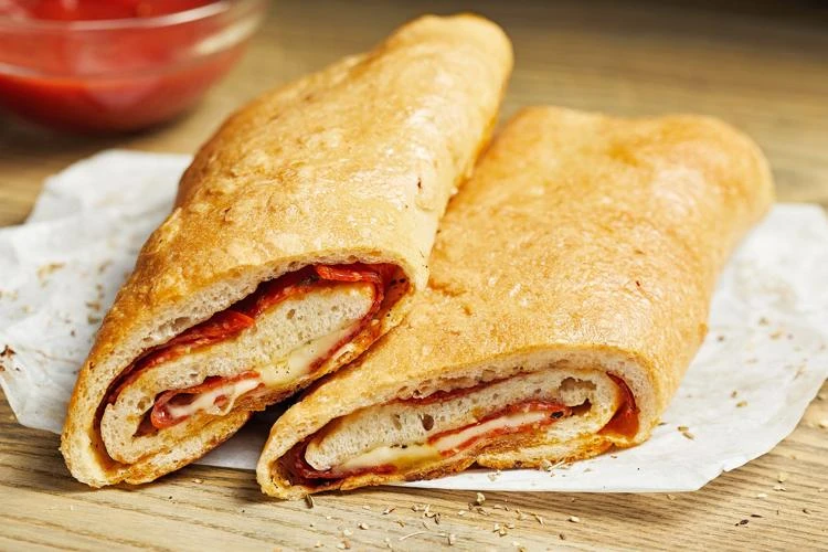 Due pezzi di stromboli su un pezzo di carta forno