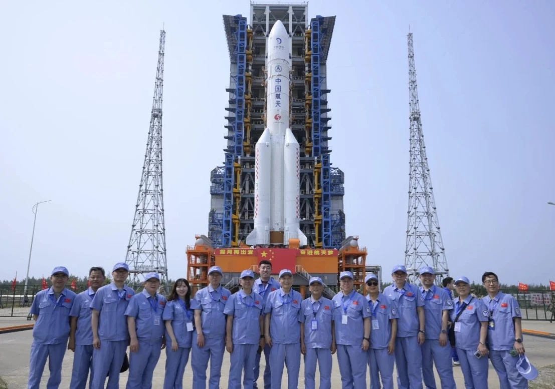 Alcuni dei tecnici che hanno lavorato alla missione Chang'e 6 immortalati di fronte al razzo che hanno progettato