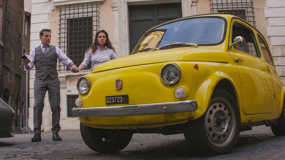 I due protagonisti di fronte ad una vecchia Fiat 500 scassata