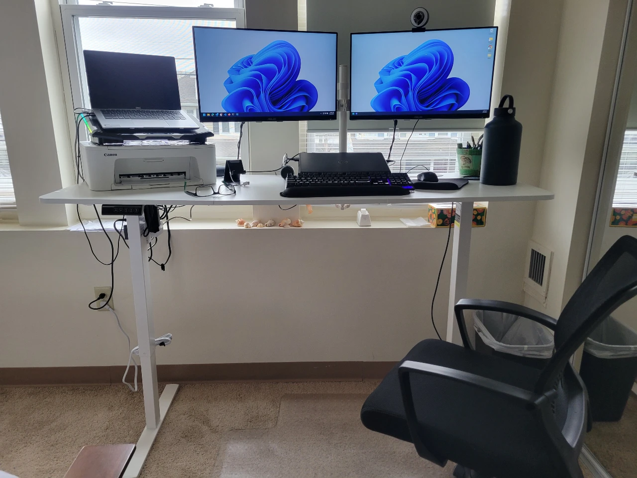 La scrivania con due monitor, i due laptop, e la sedia ergonomica